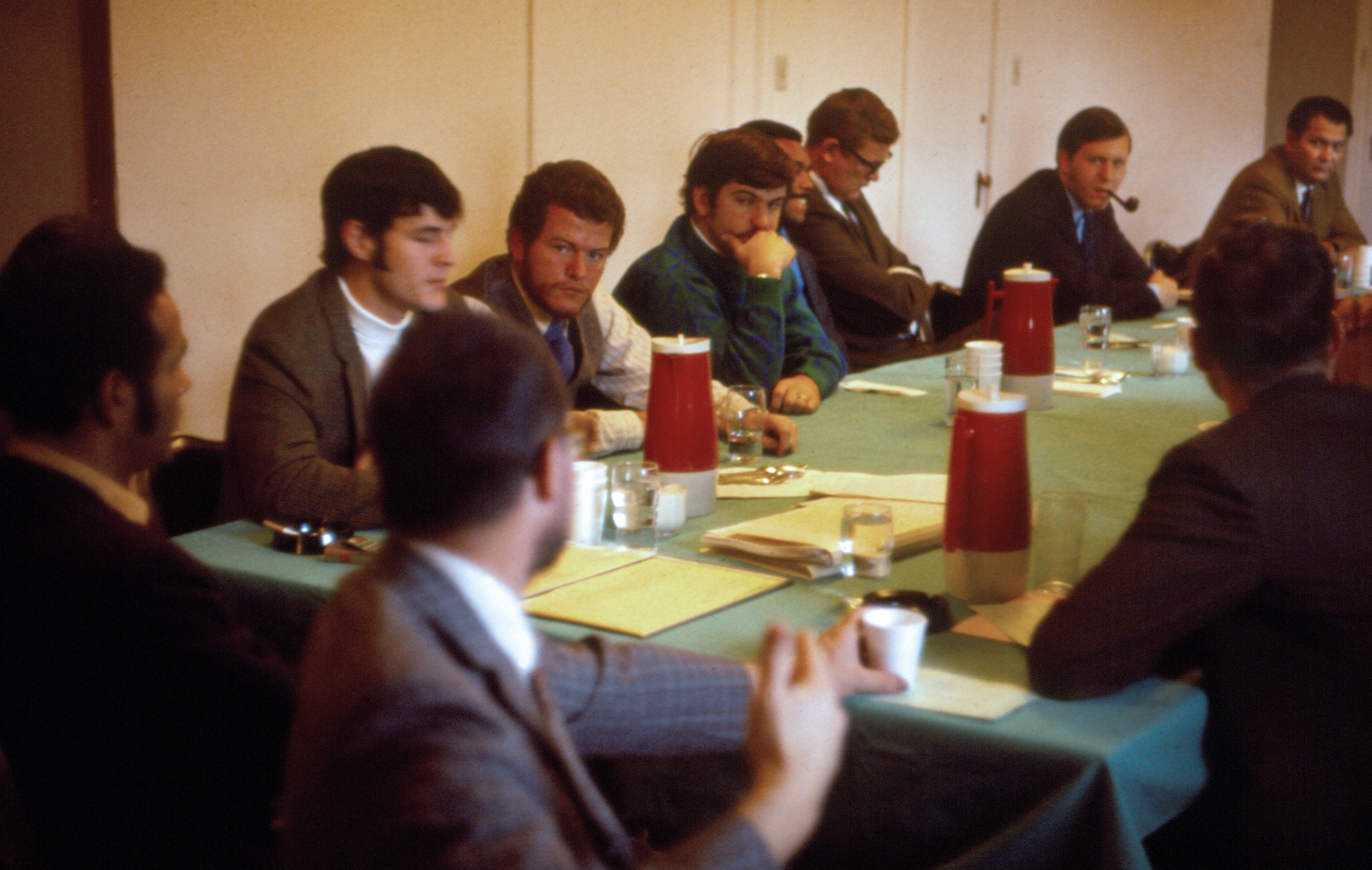 A meeting of the students and faculty of MEDEX in 1969. Dr. Richard Smith is to the far left. John Betz is at the right with a pipe.