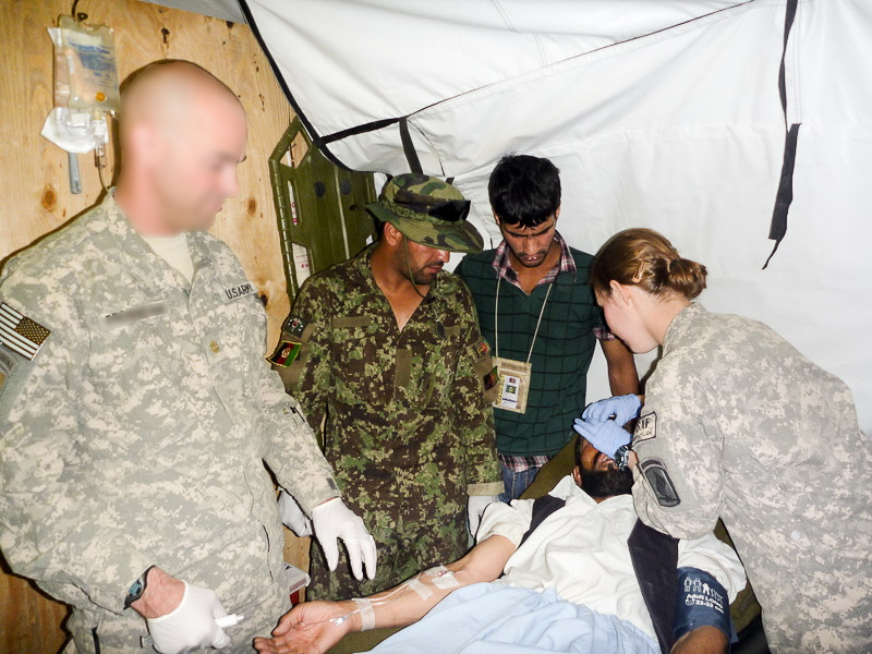 Amber sets an Afghan worker's nasal fracture. The attending Major provides conscious sedation.