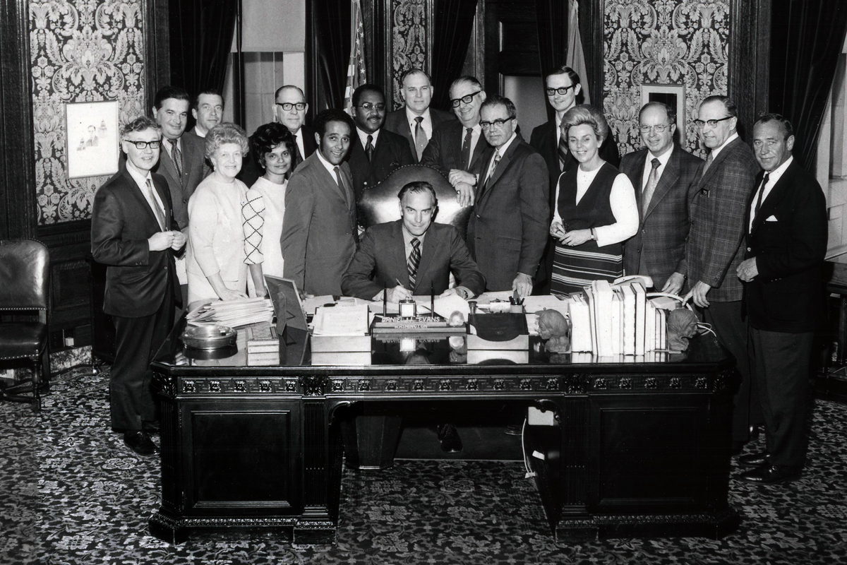 Washington State Governor Dan Evans signed into law the MEDEX enabling legislation on April 14, 1971. Smith is pictured to the left of the seated Governor.