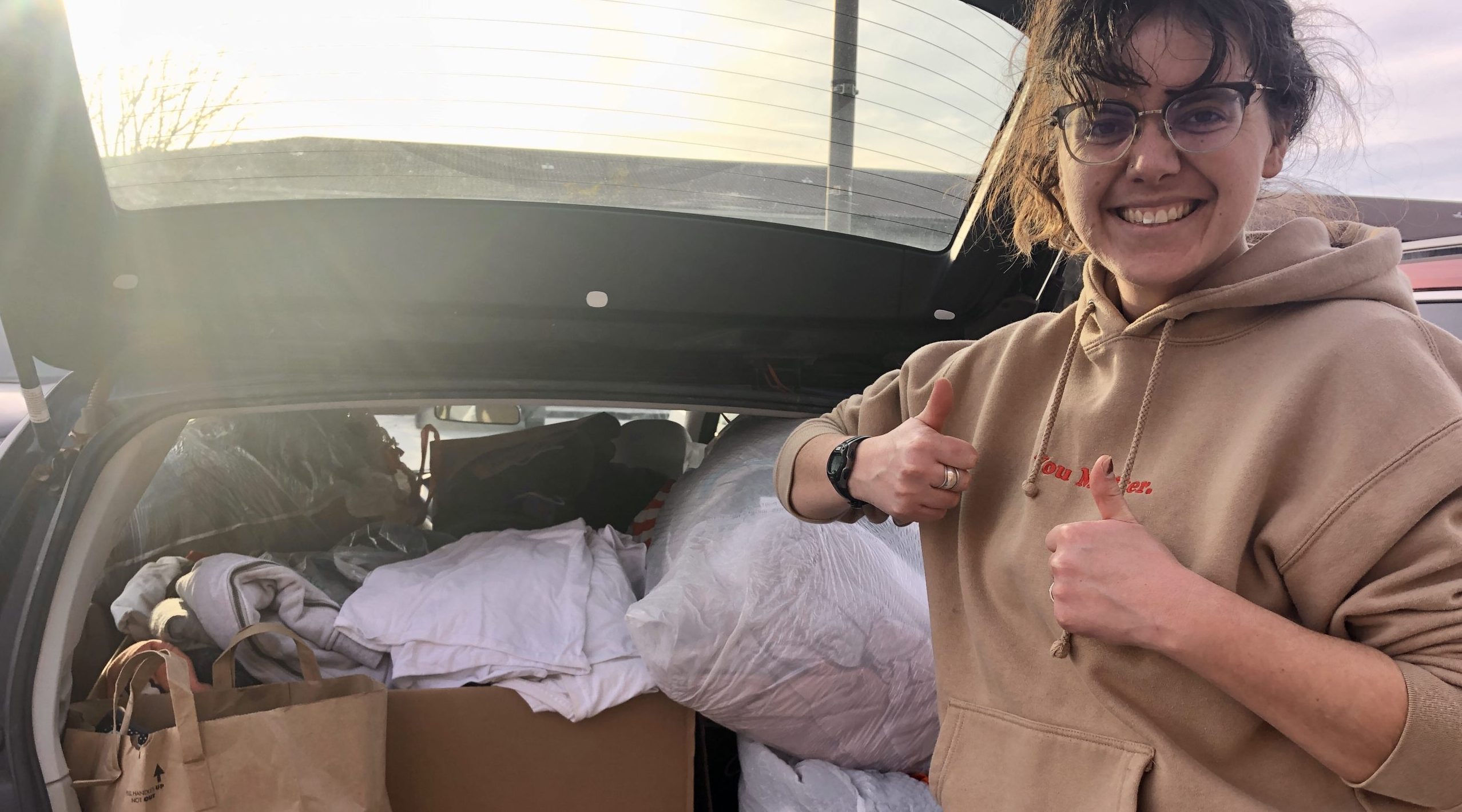 FMIG student showing off the goods from the clothing drive for shelter donations, 2024.